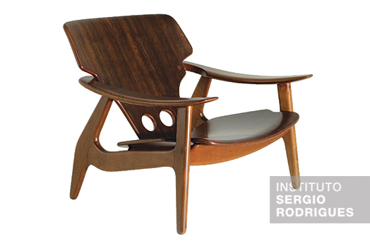 Poltrona Diz criada por Sergio Rodrigues em 2001, estruturada em madeira de lei maciça com assento e encosto em compensado.
