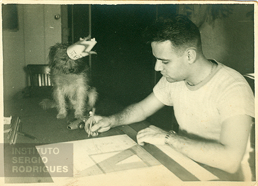 Sergio Rodrigues at age 20, making a technical drawing next to his dog Pipoca, at Castelinho, at Praia do Flamengo, No. 72 - Rio de Janeiro, in 1947.