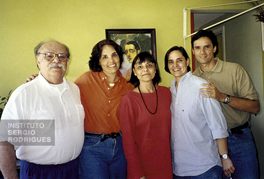 From left to right, Sergio Rodrigues next to his kids Ângela, Verônica, Adriana, and Roberto, at his home, in Rio de Janeiro, in the 2000s. In the background, self-portrait of Roberto Rodrigues, Sergio's father.