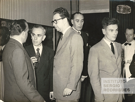 Inauguração da Loja Móveis Artesanal Paranaense em Curitiba, no ano de 1953, com presença do Conde Paolo Grasselli (à esquerda, posicionado de costas) e do designer Enesto Hauner (na extrema direita da fotografia, posicionado de frente).